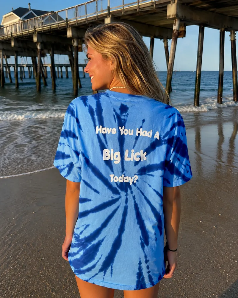 The back of the tie-dye Big Licks t-shirt on a woman, reading Have You Had A Big Lick Today?